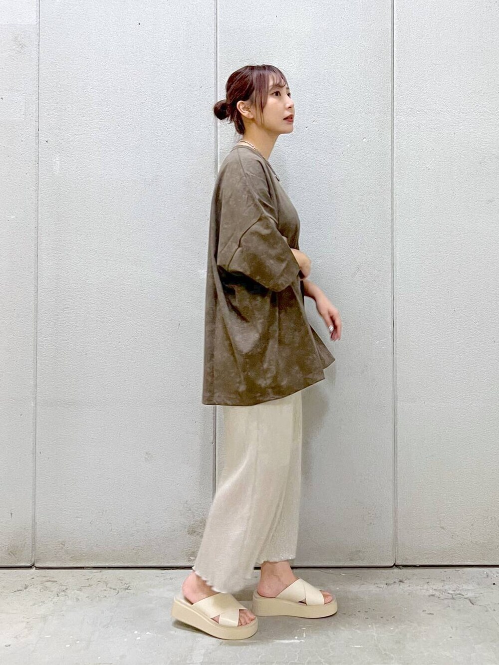 ホワイト系のスカート、ホワイト系のサンダル、ブラウン系のTシャツ/カットソーを着用したレディースの夏コーディネートの3枚目の写真