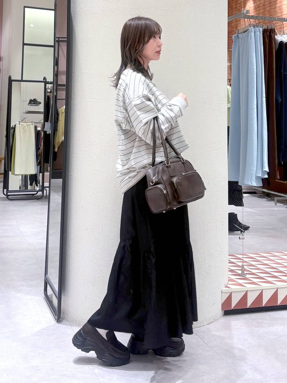 ブラウン系のボストンバッグ、ブラウン系のローファー、グレー系のTシャツ/カットソーを着用したレディースの冬コーディネートの4枚目の写真