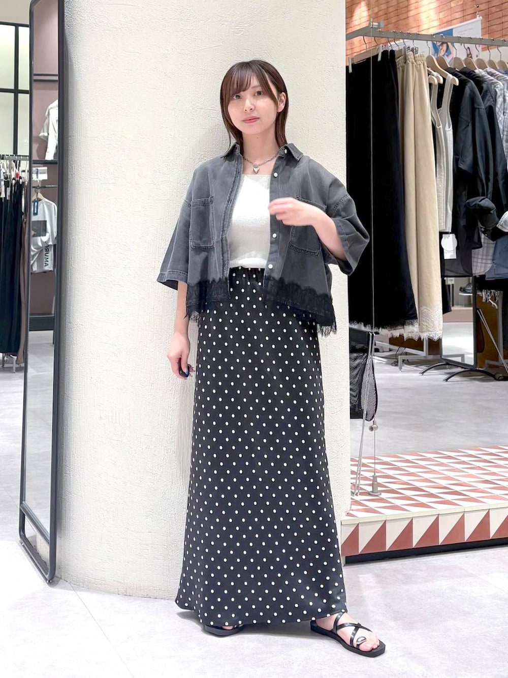 ブラック系のスカート、シルバー系のタンクトップ、ブラック系のサンダルを着用したレディースの夏コーディネートの3枚目の写真