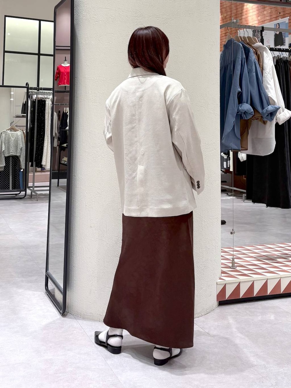 ブラウン系のスカート、ベージュ系のその他アウター、ブラック系のサンダルを着用したレディースの春コーディネートの2枚目の写真