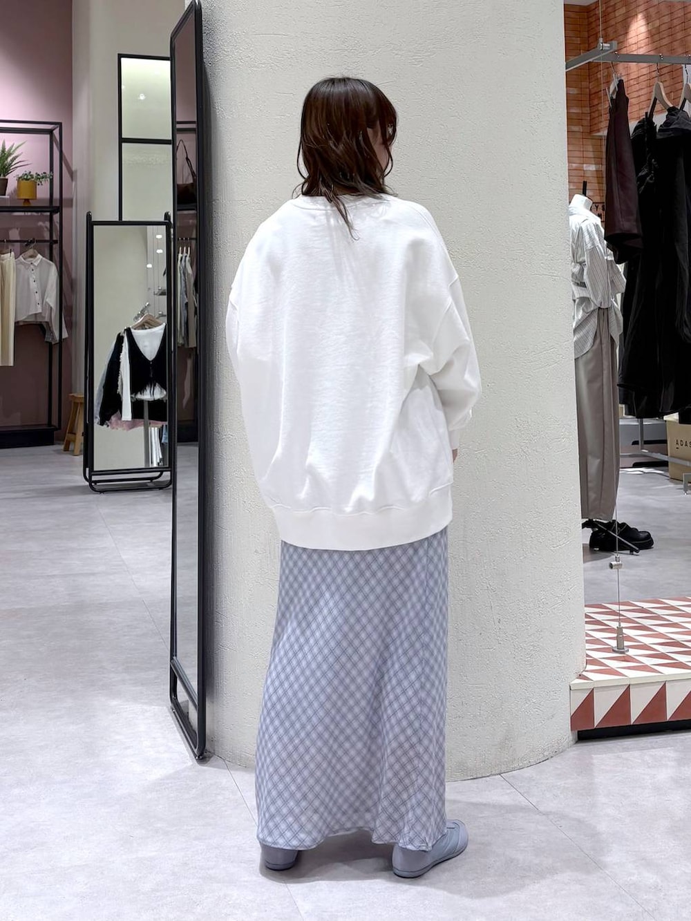 ブルー系のスニーカー、ホワイト系のスウェット、ブルー系のスカートを着用したレディースの春コーディネートの3枚目の写真