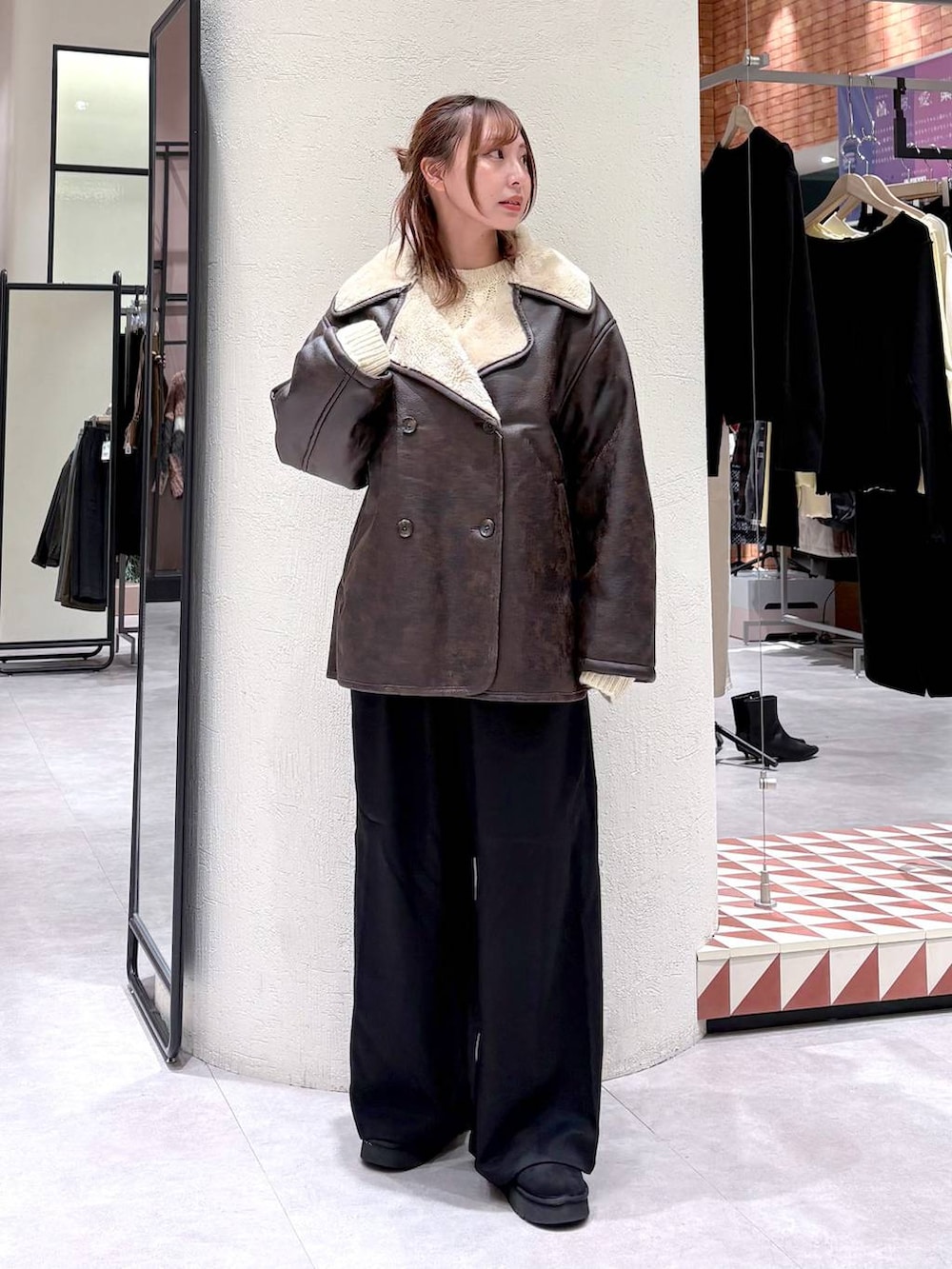 ブラウン系のムートンコート、ブラック系のその他パンツ、ブラック系のブーツを着用したレディースの冬コーディネートの3枚目の写真