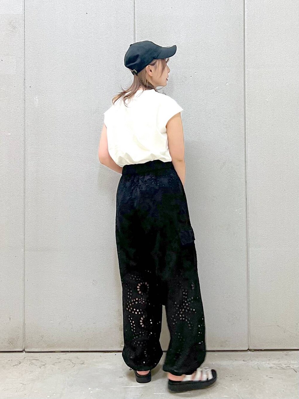 ブラック系のハンドバッグ、シルバー系のスニーカー、ブラック系のカーゴパンツを着用したレディースの春コーディネートの2枚目の写真