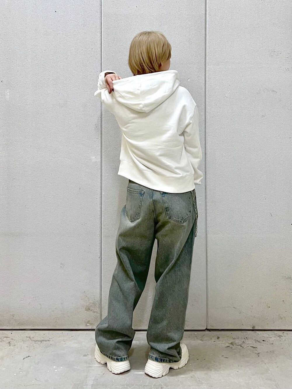 ブルー系のデニムパンツ、ホワイト系のスニーカー、ホワイト系のTシャツ/カットソーを着用したレディースの秋コーディネートの4枚目の写真