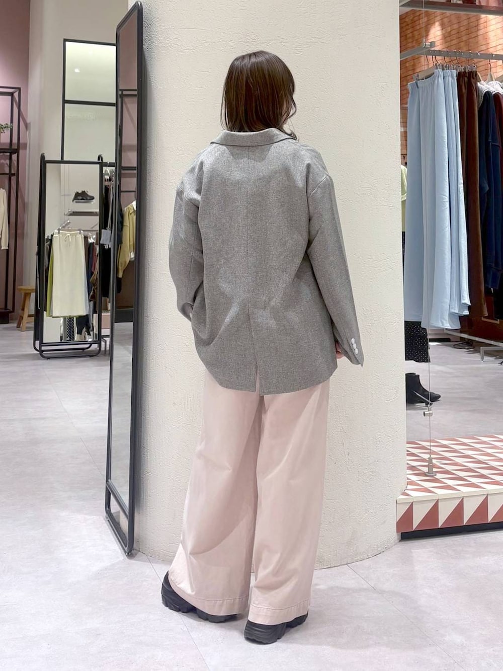 グレー系のテーラードジャケット、ピンク系のデニムパンツ、ブラック系のローファーを着用したレディースの冬コーディネートの3枚目の写真