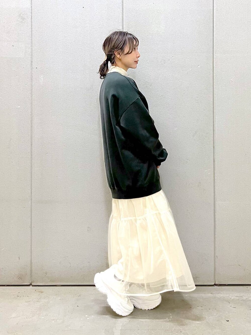 ホワイト系のニット/セーター、ホワイト系のスカート、ホワイト系のスニーカーを着用したレディースの秋コーディネートの3枚目の写真