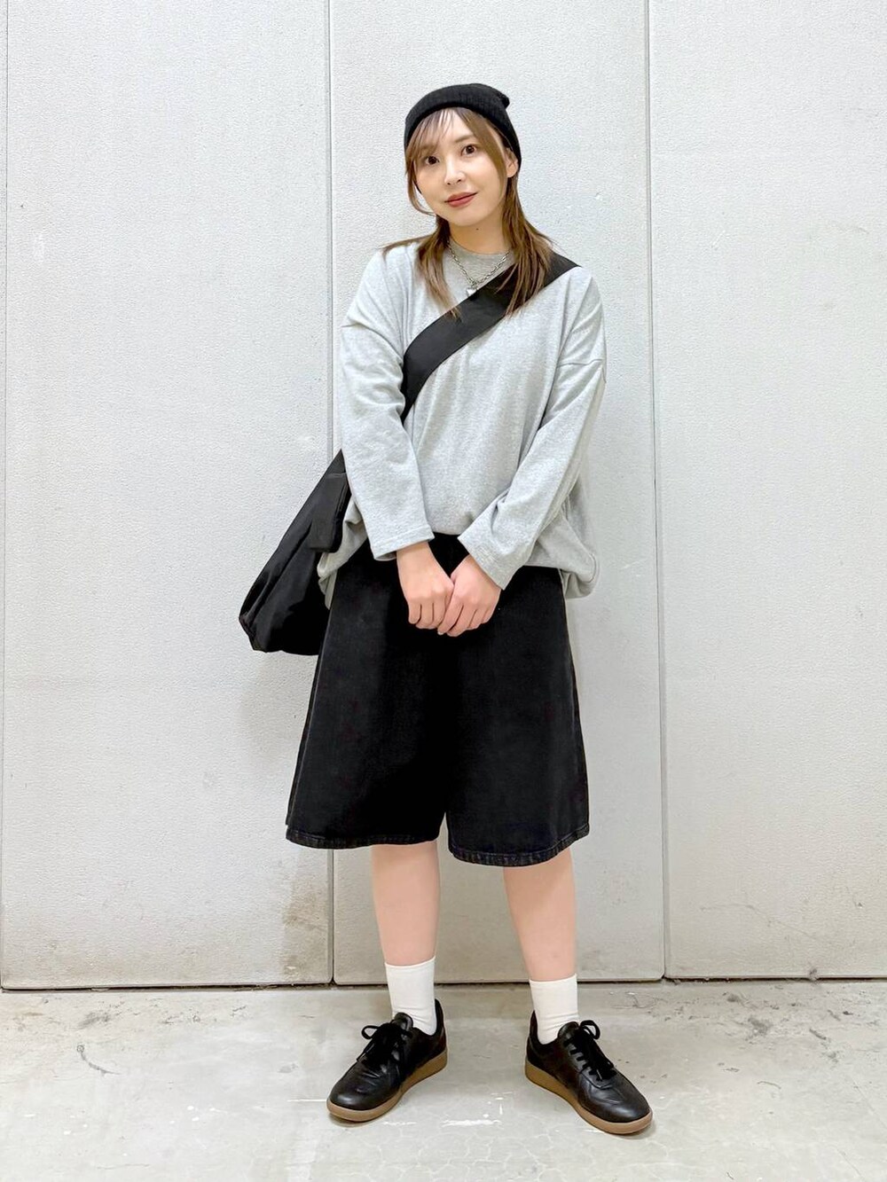 グレー系のワンピース、ブラック系のショルダーバッグ、ブラック系のスニーカーを着用したレディースの春コーディネートの7枚目の写真