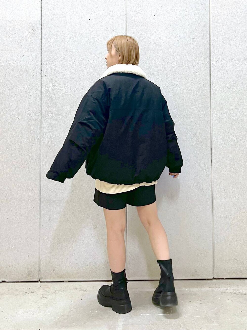ホワイト系のニット/セーター、ブラック系のその他パンツ、ブラック系のブーツを着用したレディースの冬コーディネートの2枚目の写真