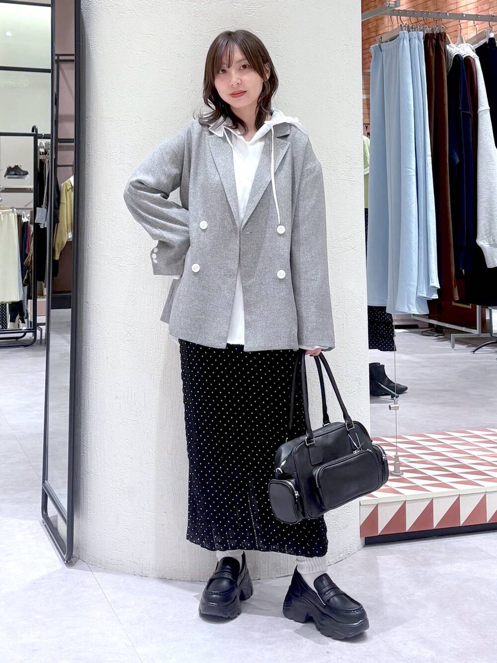 ホワイト系のシャツ/ブラウス、グレー系のテーラードジャケット、ブラック系のボストンバッグを着用したレディースの冬コーディネートの2枚目の写真