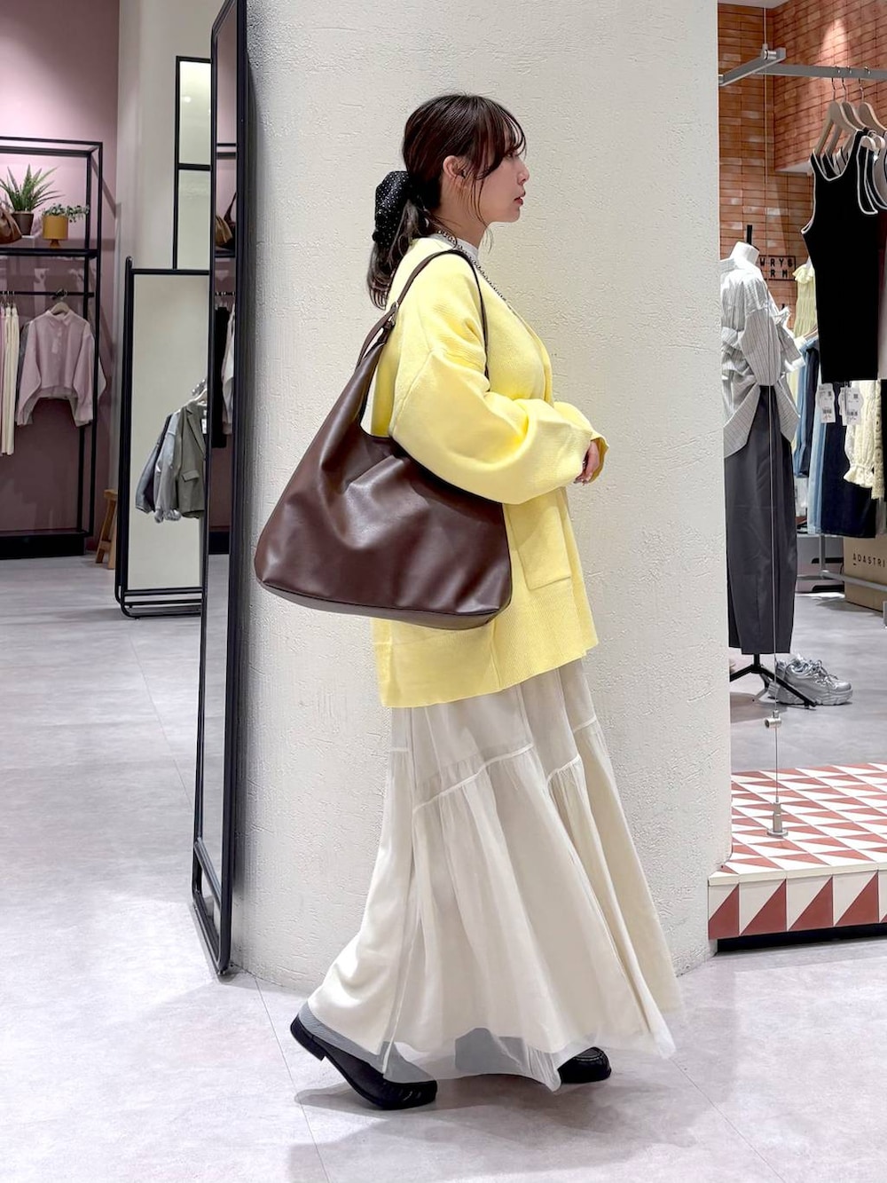 ブラウン系のショルダーバッグ、ブラウン系のローファー、ホワイト系のスカートを着用したレディースの春コーディネートの3枚目の写真