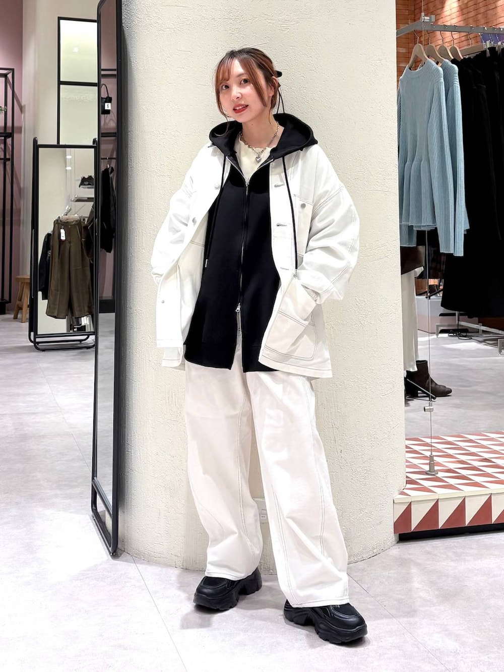 ブラック系のパーカー、ホワイト系のデニムパンツ、ホワイト系のデニムジャケットを着用したレディースの冬コーディネートの2枚目の写真