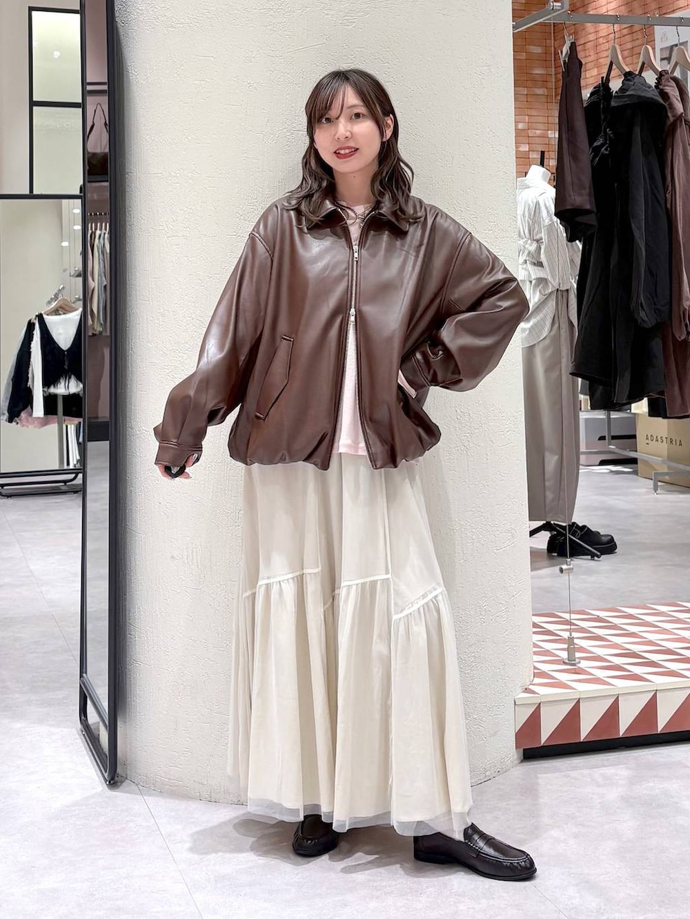 ピンク系のTシャツ/カットソー、ブラウン系のブルゾン、ブラウン系のローファーを着用したレディースの春コーディネートの2枚目の写真