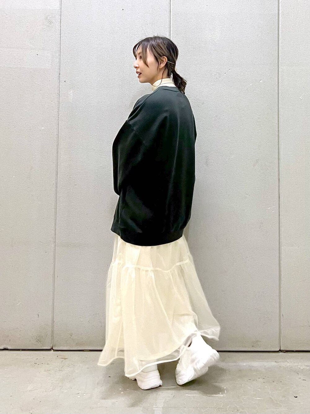 ホワイト系のニット/セーター、ホワイト系のスカート、ホワイト系のスニーカーを着用したレディースの秋コーディネートの4枚目の写真