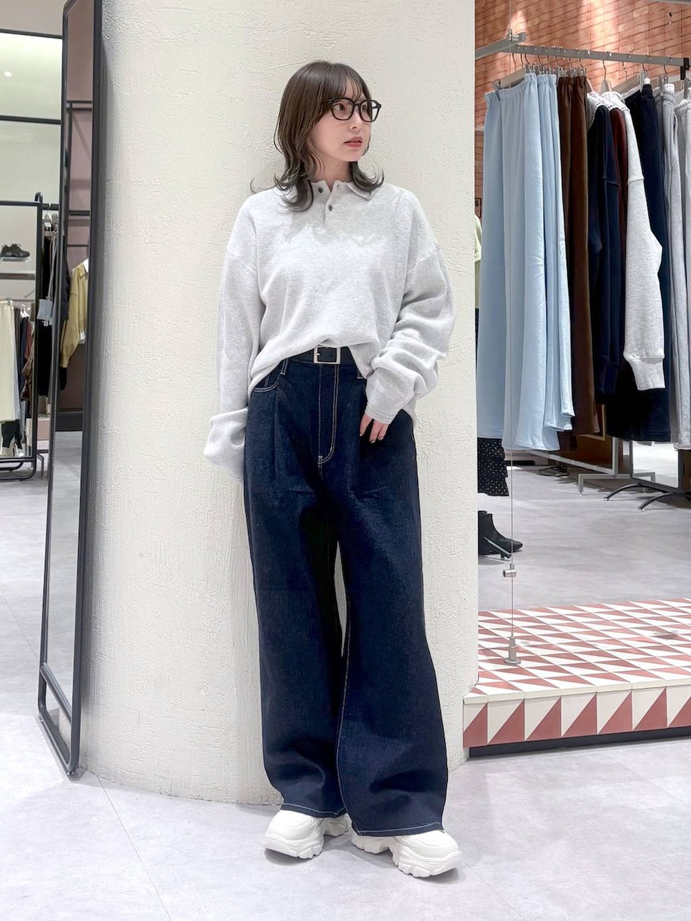 ブルー系のデニムパンツ、グレー系のニット/セーター、ホワイト系のスニーカーを着用したレディースの冬コーディネートの5枚目の写真