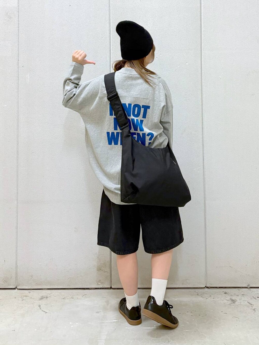 グレー系のワンピース、ブラック系のショルダーバッグ、ブラック系のスニーカーを着用したレディースの春コーディネートの3枚目の写真