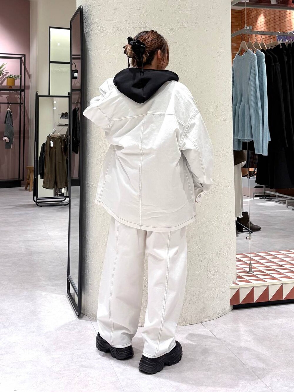 ブラック系のパーカー、ホワイト系のデニムパンツ、ホワイト系のデニムジャケットを着用したレディースの冬コーディネートの3枚目の写真