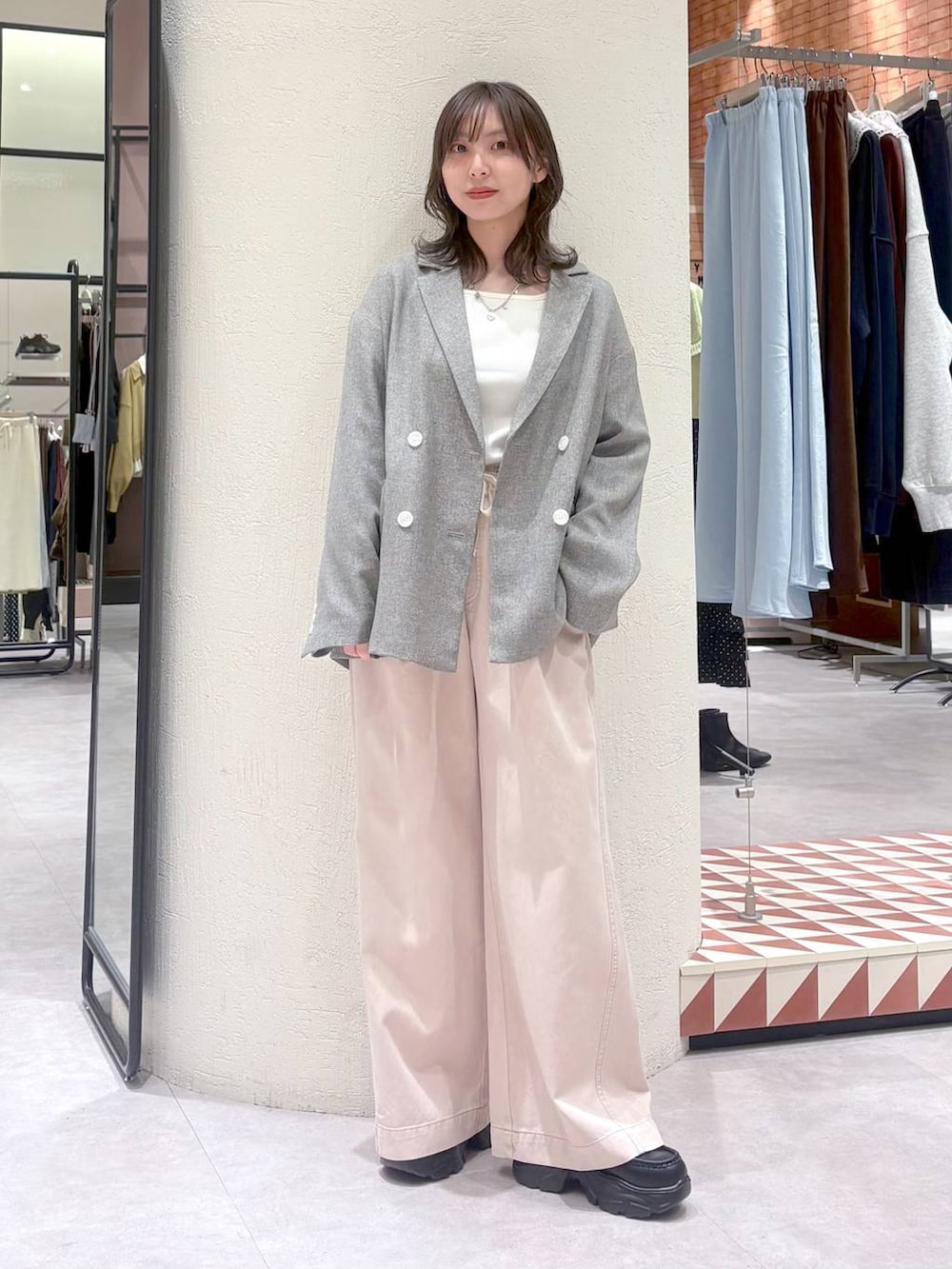 グレー系のテーラードジャケット、ピンク系のデニムパンツ、ブラック系のローファーを着用したレディースの冬コーディネートの6枚目の写真