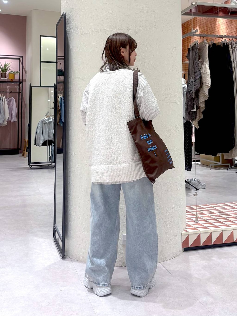 ブルー系のデニムパンツ、ブラウン系のトートバッグ、グレー系のシャツ/ブラウスを着用したレディースの春コーディネートの3枚目の写真