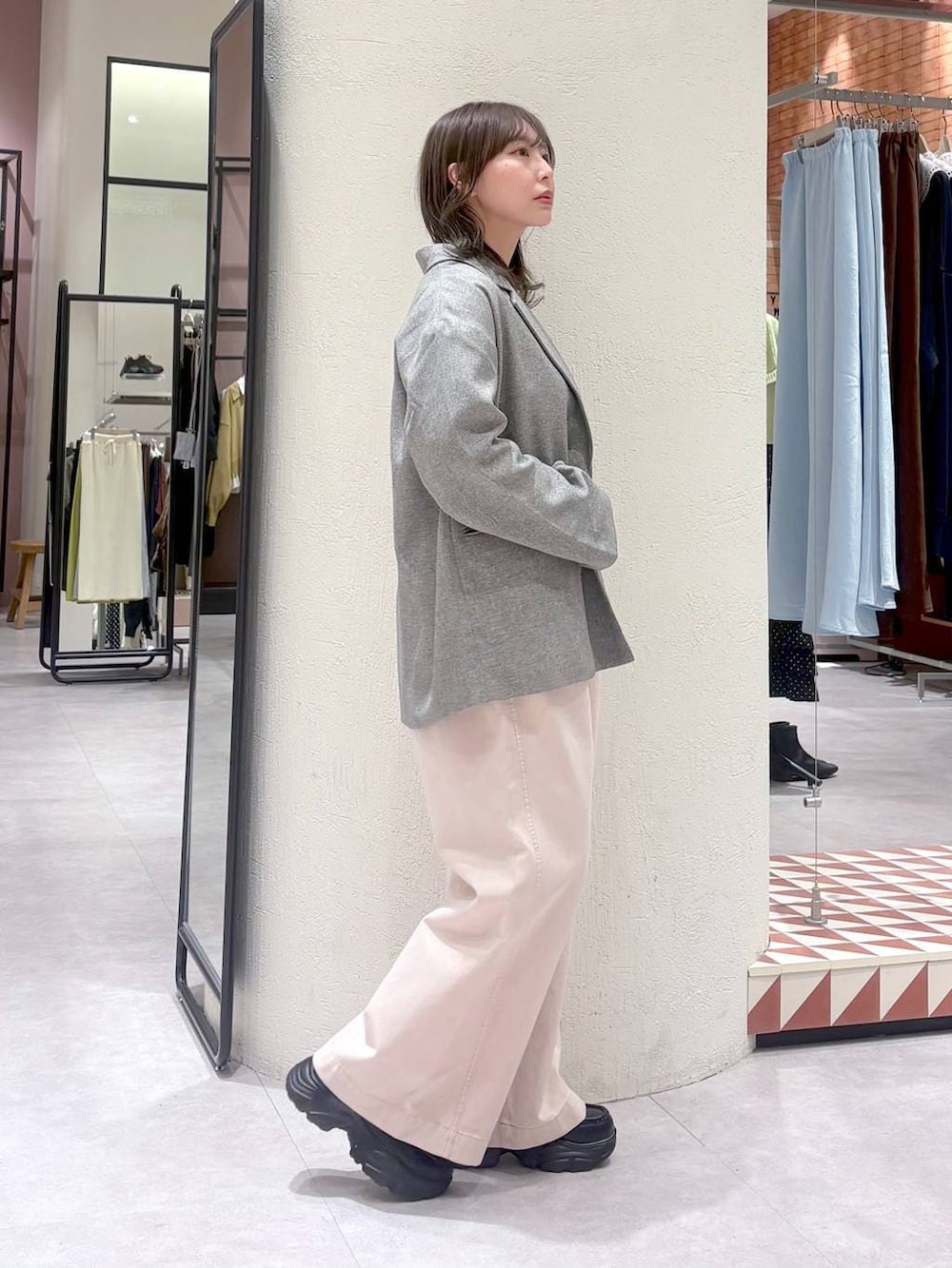 グレー系のテーラードジャケット、ピンク系のデニムパンツ、ブラック系のローファーを着用したレディースの冬コーディネートの4枚目の写真