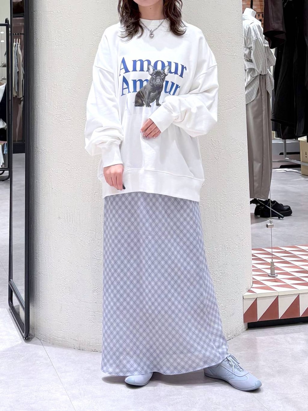 ブルー系のスニーカー、ホワイト系のスウェット、ブルー系のスカートを着用したレディースの春コーディネートの2枚目の写真