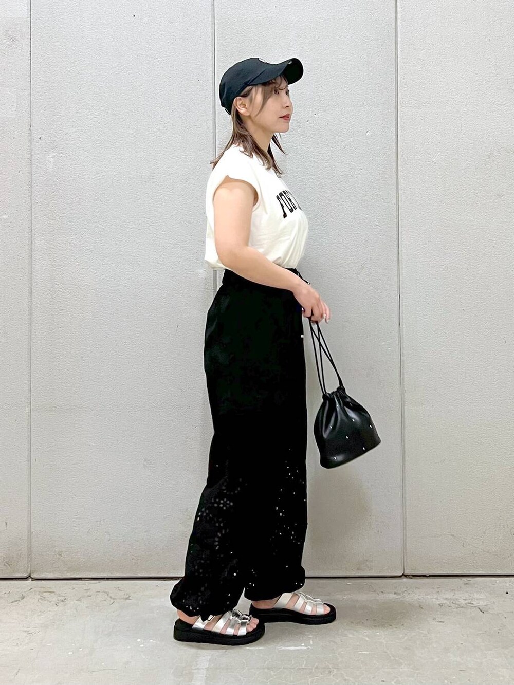 ブラック系のハンドバッグ、シルバー系のスニーカー、ブラック系のカーゴパンツを着用したレディースの春コーディネートの3枚目の写真