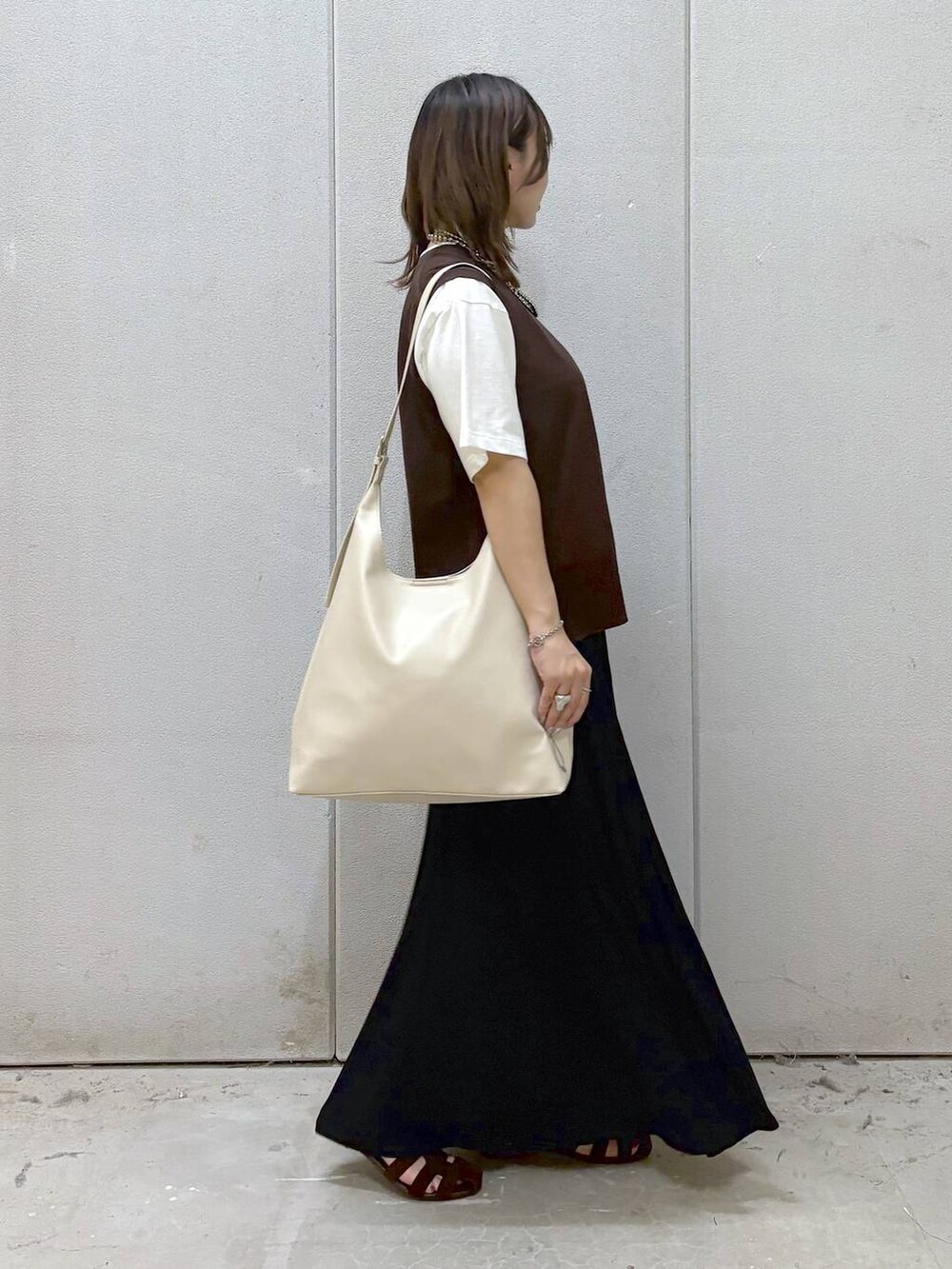 ホワイト系のショルダーバッグ、ホワイト系のTシャツ/カットソー、ブラウン系のサンダルを着用したレディースの夏コーディネートの4枚目の写真