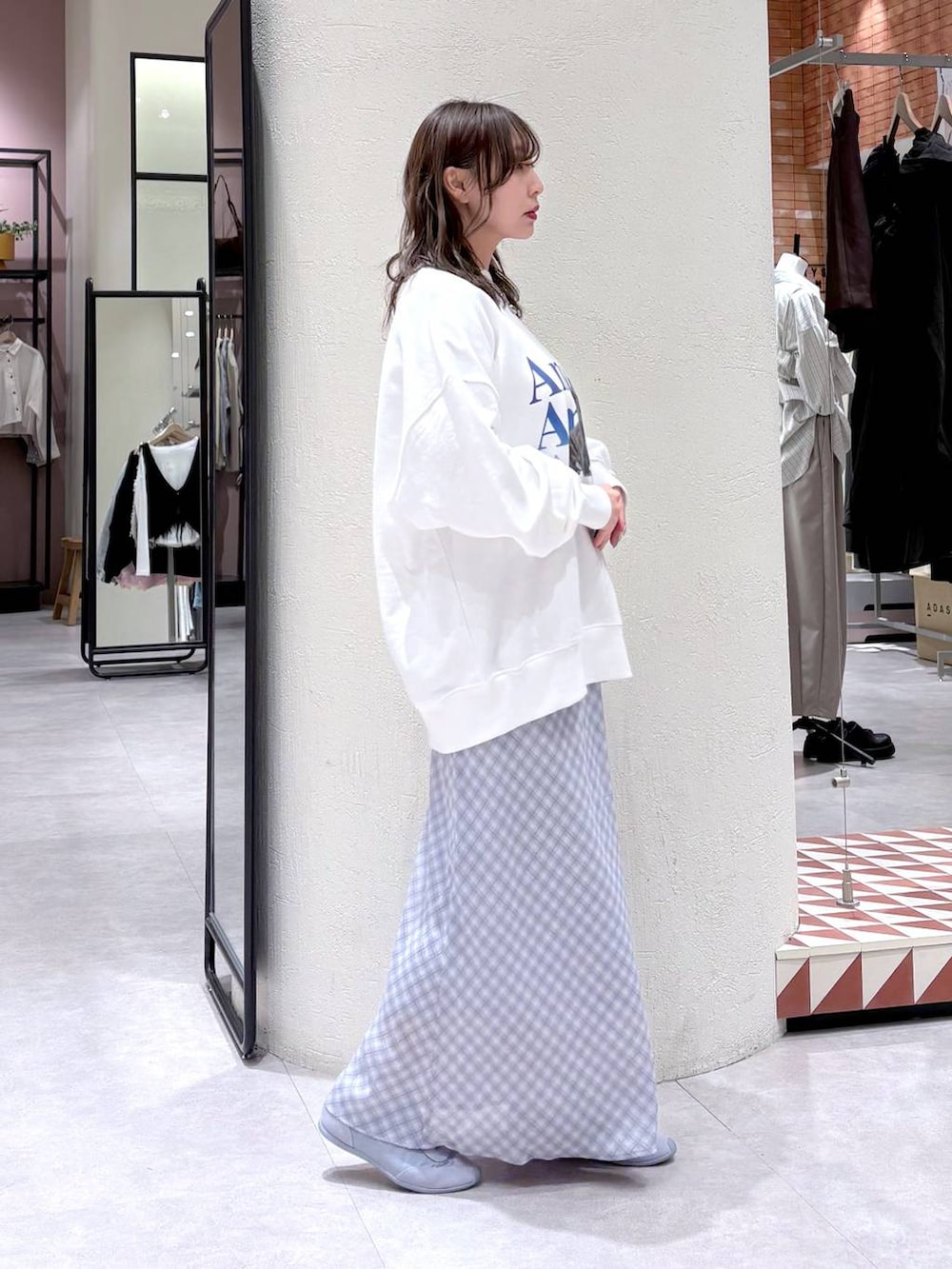 ブルー系のスニーカー、ホワイト系のスウェット、ブルー系のスカートを着用したレディースの春コーディネートの4枚目の写真