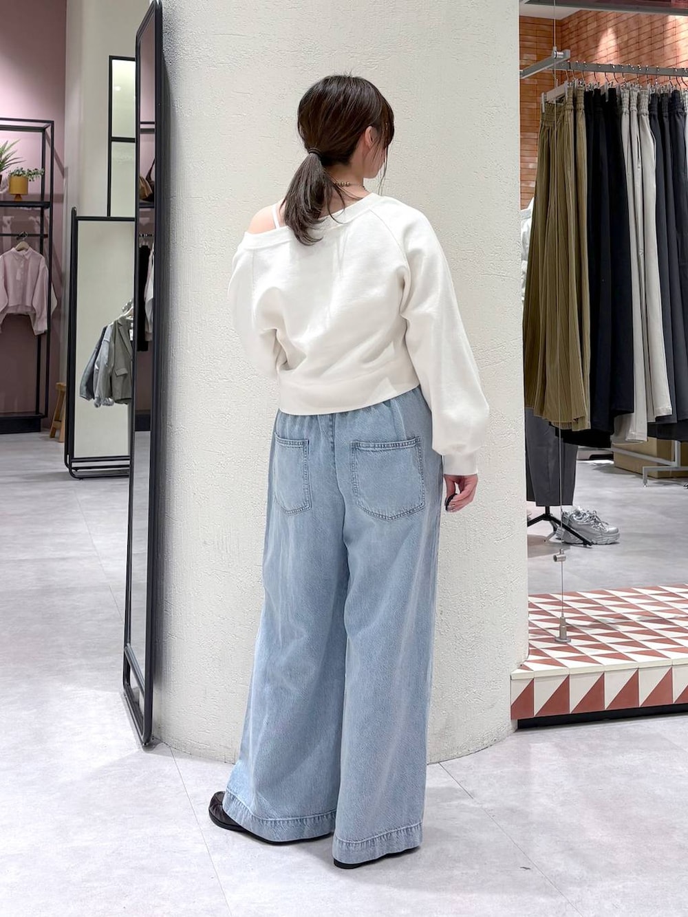 ホワイト系のTシャツ/カットソー、ブルー系のデニムパンツ、ブラウン系のローファーを着用したレディースの春コーディネートの2枚目の写真