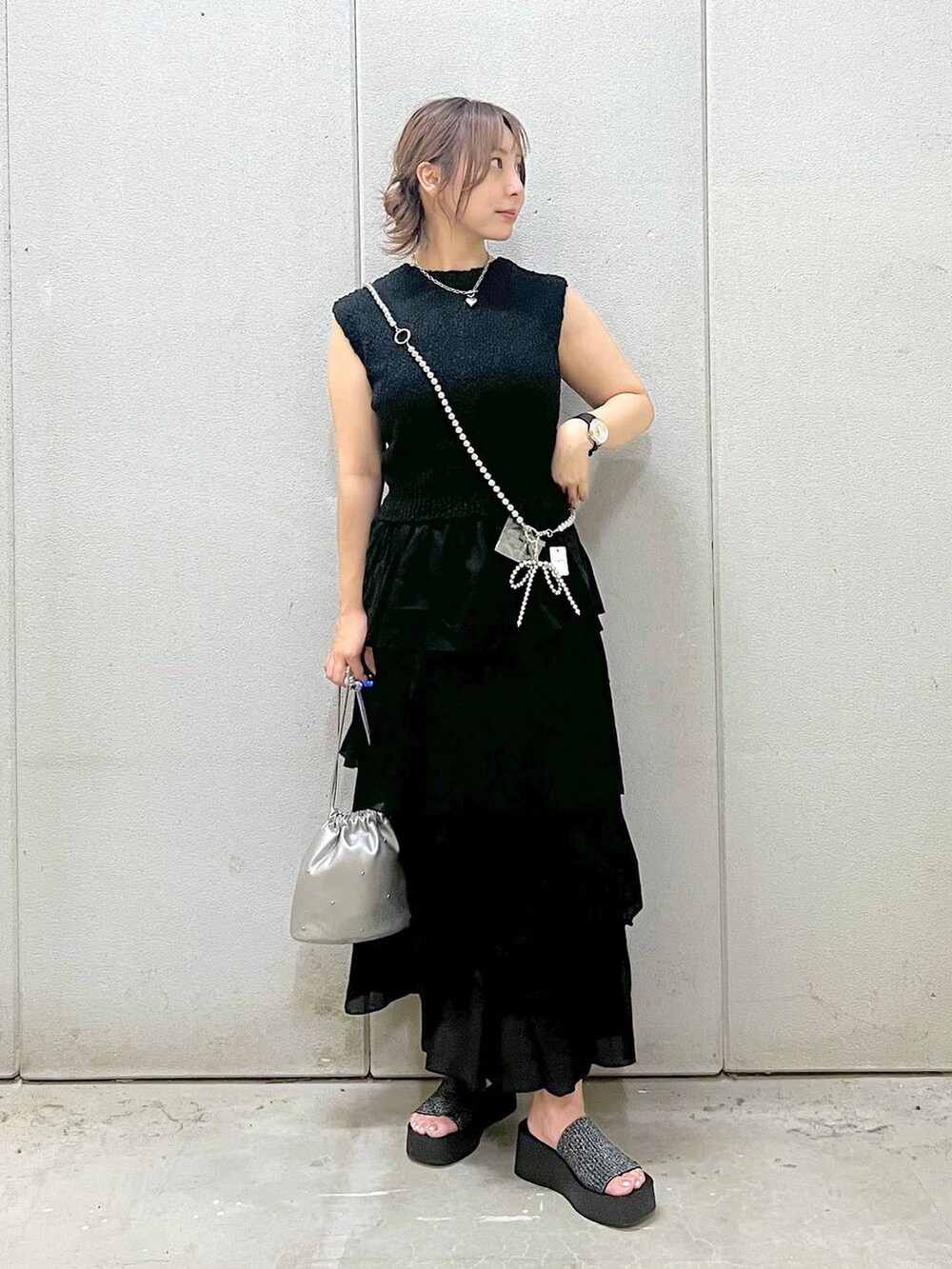 ホワイト系のTシャツ/カットソー、ブラック系のサンダル、シルバー系のショルダーバッグを着用したレディースの夏コーディネートの4枚目の写真