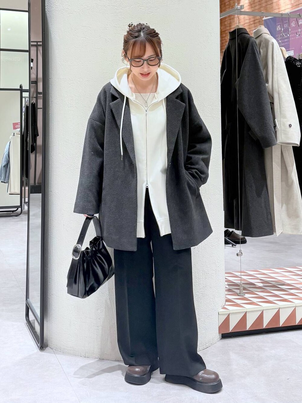 ベージュ系のパーカー、グレー系のその他アウター、ブラック系のスラックスを着用したレディースの冬コーディネートの5枚目の写真