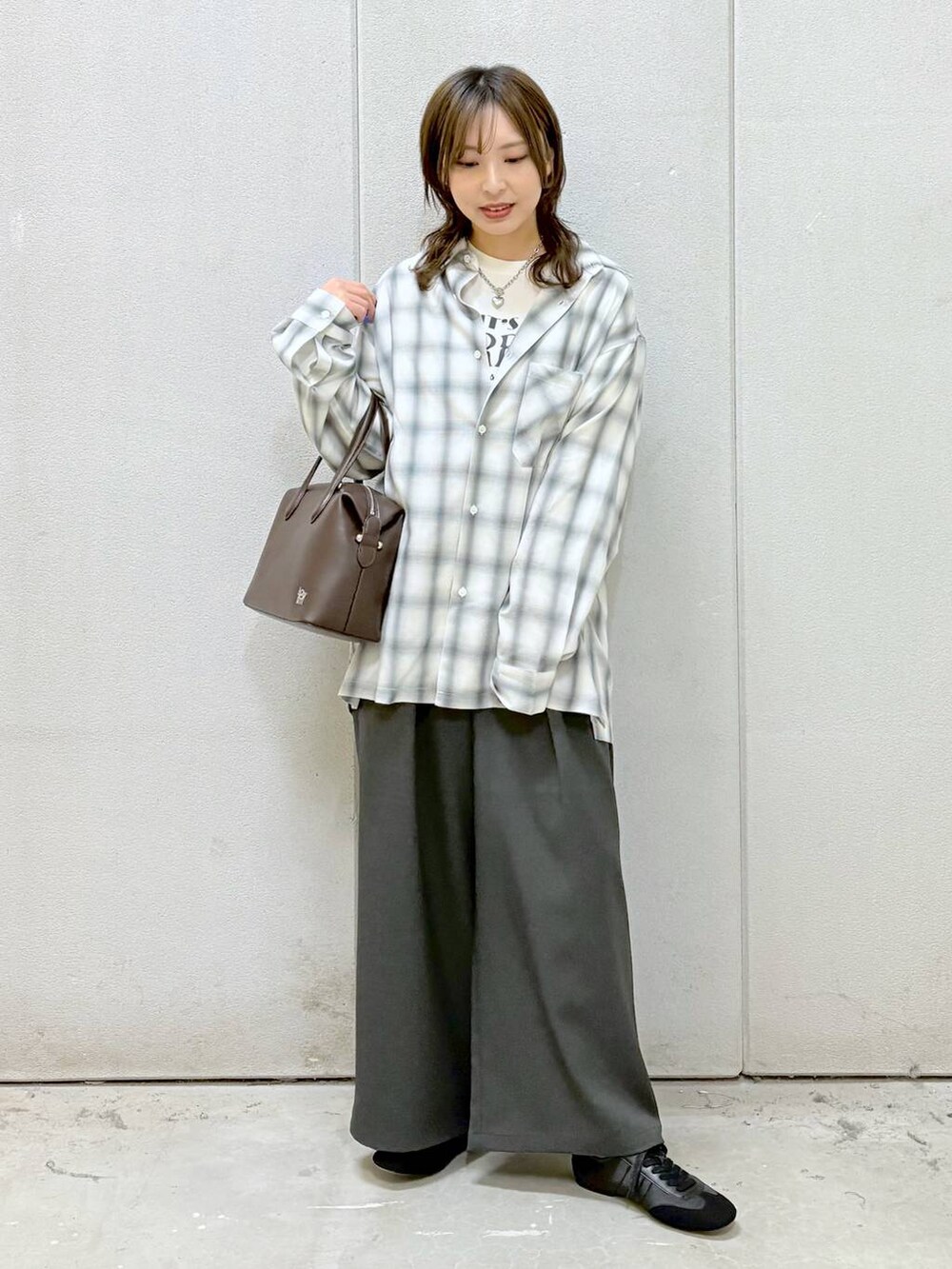 ホワイト系のTシャツ/カットソー、ブラウン系のショルダーバッグ、ブラック系のスニーカーを着用したレディースの冬コーディネートの5枚目の写真