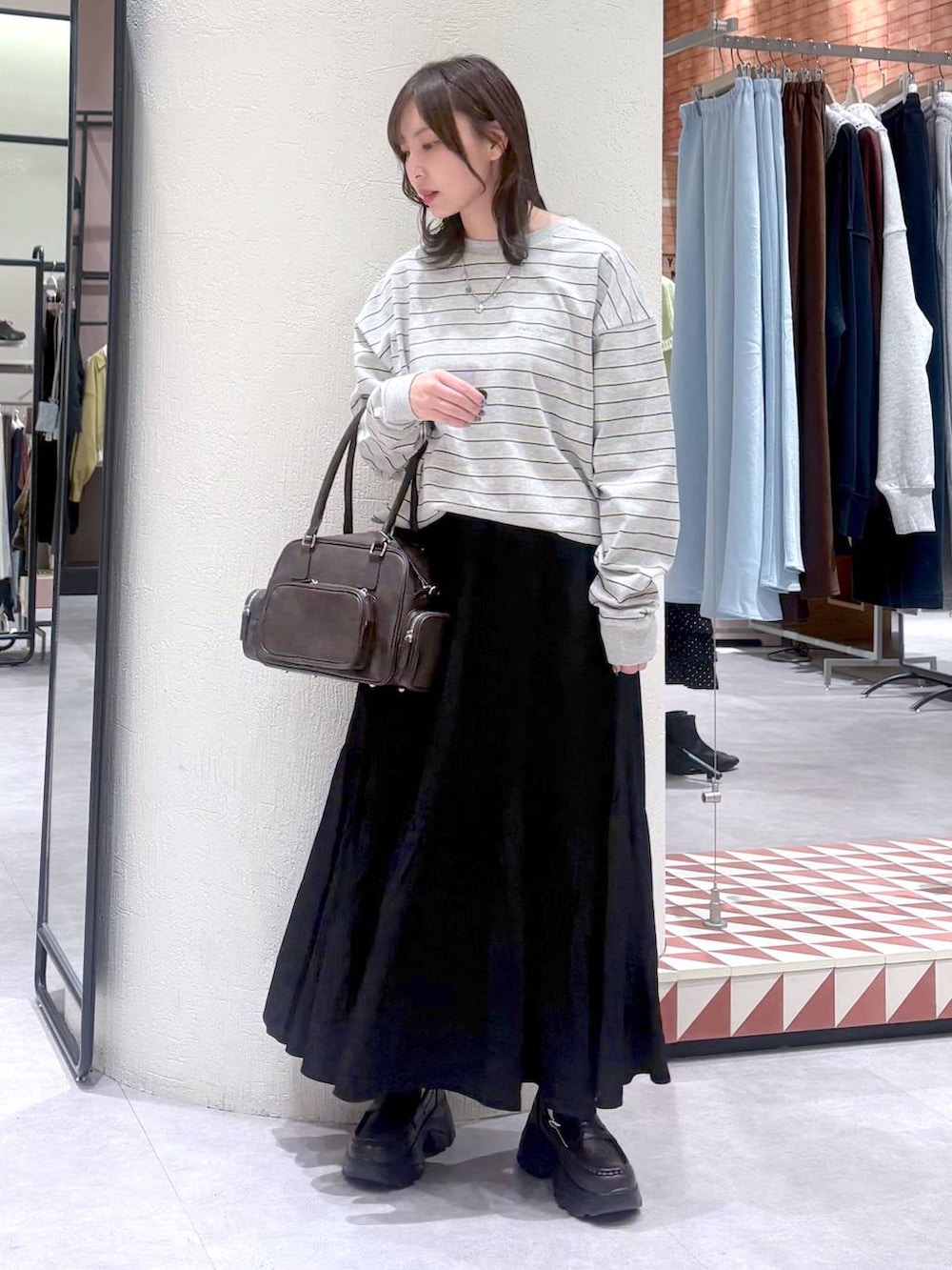 ブラウン系のボストンバッグ、ブラウン系のローファー、グレー系のTシャツ/カットソーを着用したレディースの冬コーディネートの6枚目の写真