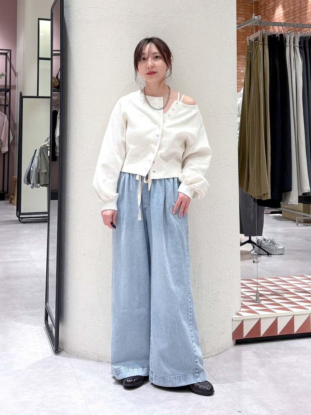 ホワイト系のTシャツ/カットソー、ブルー系のデニムパンツ、ブラウン系のローファーを着用したレディースの春コーディネートの4枚目の写真