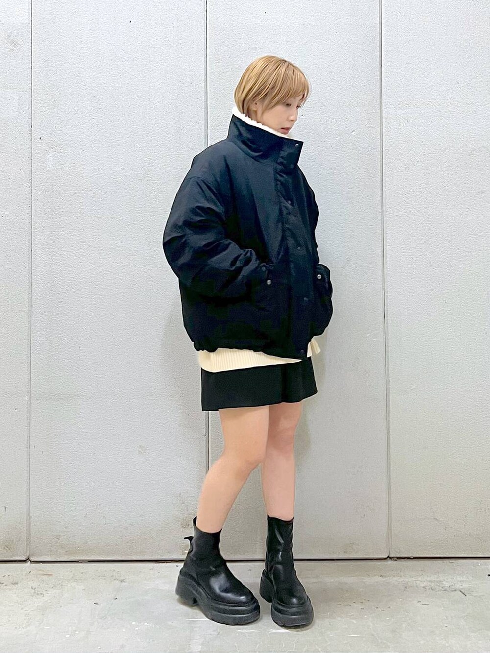 ホワイト系のニット/セーター、ブラック系のその他パンツ、ブラック系のブーツを着用したレディースの冬コーディネートの4枚目の写真