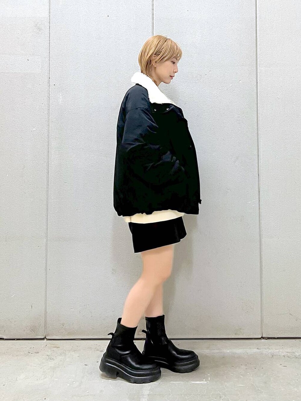 ホワイト系のニット/セーター、ブラック系のその他パンツ、ブラック系のブーツを着用したレディースの冬コーディネートの3枚目の写真