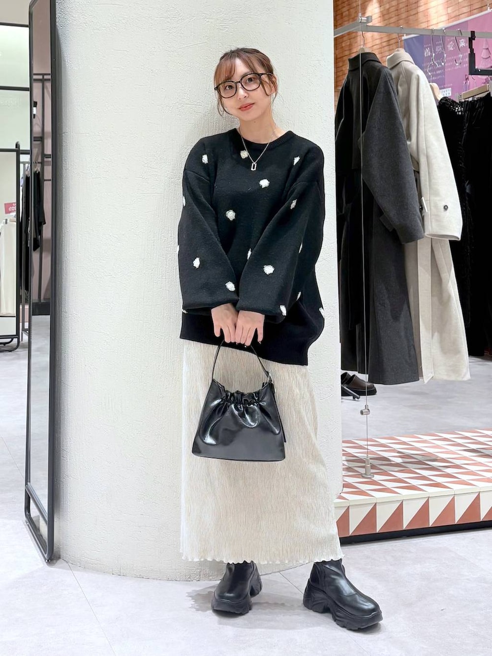 ブラック系のブーツ、グリーン系のその他アウター、ホワイト系のスカートを着用したレディースの冬コーディネートの6枚目の写真