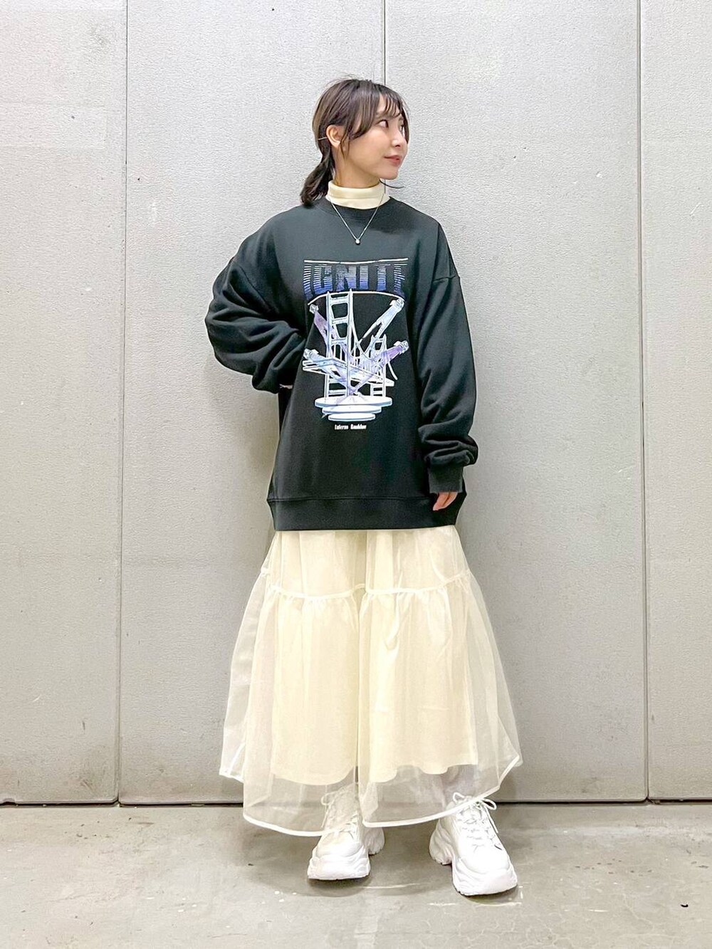 ホワイト系のニット/セーター、ホワイト系のスカート、ホワイト系のスニーカーを着用したレディースの秋コーディネートの2枚目の写真