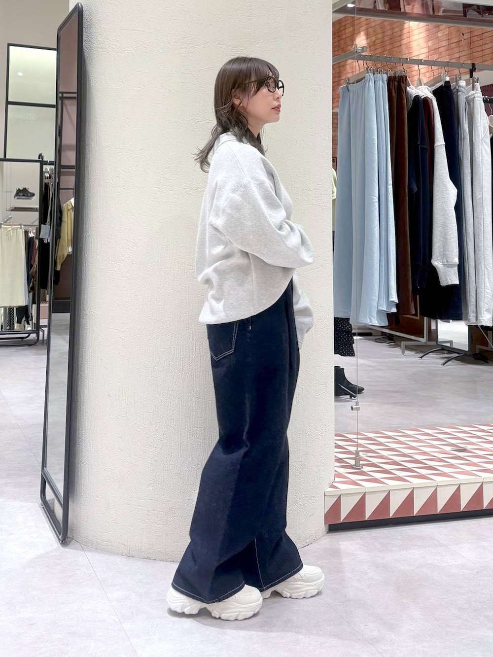 ブルー系のデニムパンツ、グレー系のニット/セーター、ホワイト系のスニーカーを着用したレディースの冬コーディネートの4枚目の写真