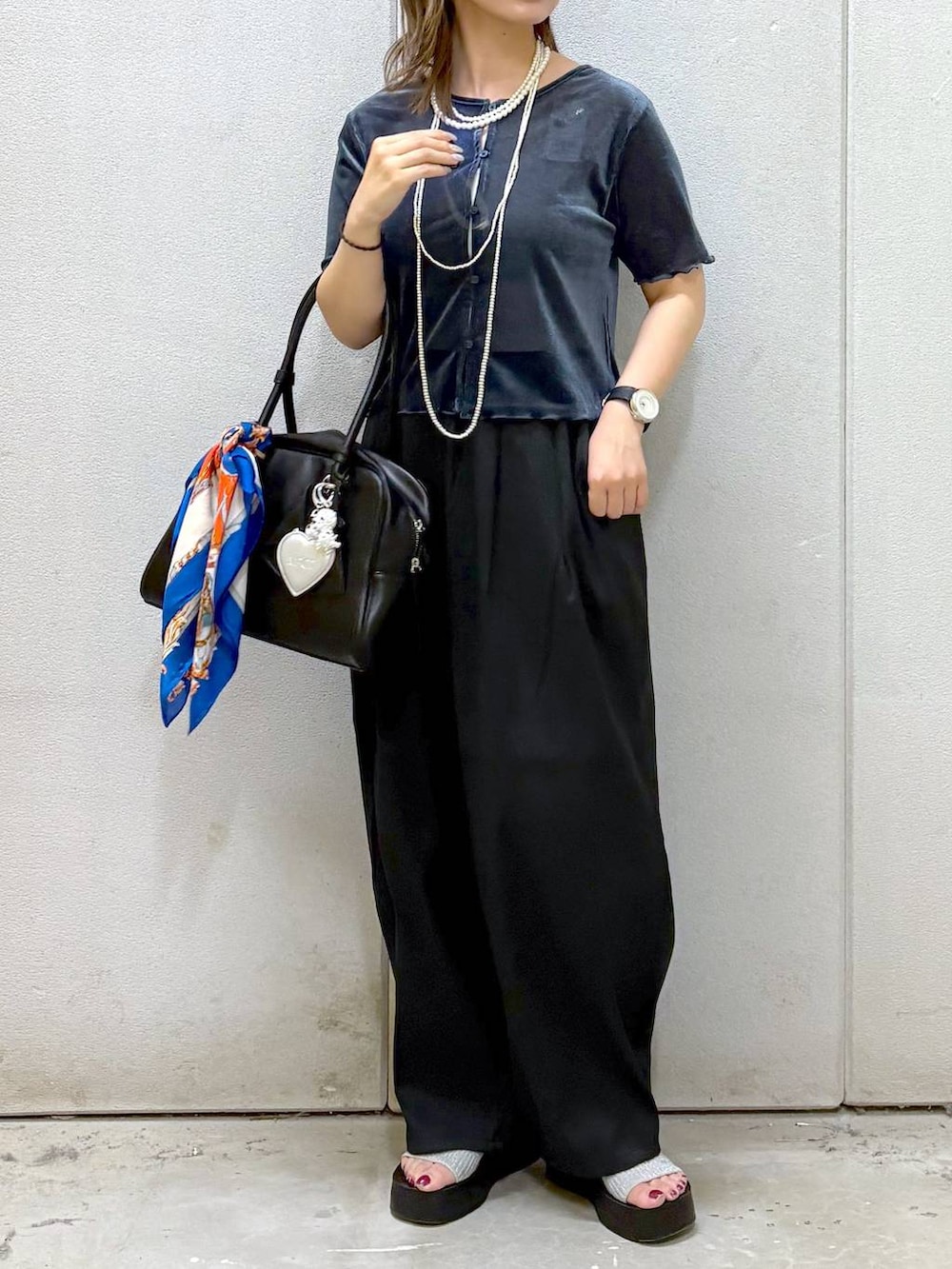 シルバー系のサンダル、ブラック系のその他パンツ、ブラック系のボストンバッグを着用したレディースの夏コーディネートの2枚目の写真