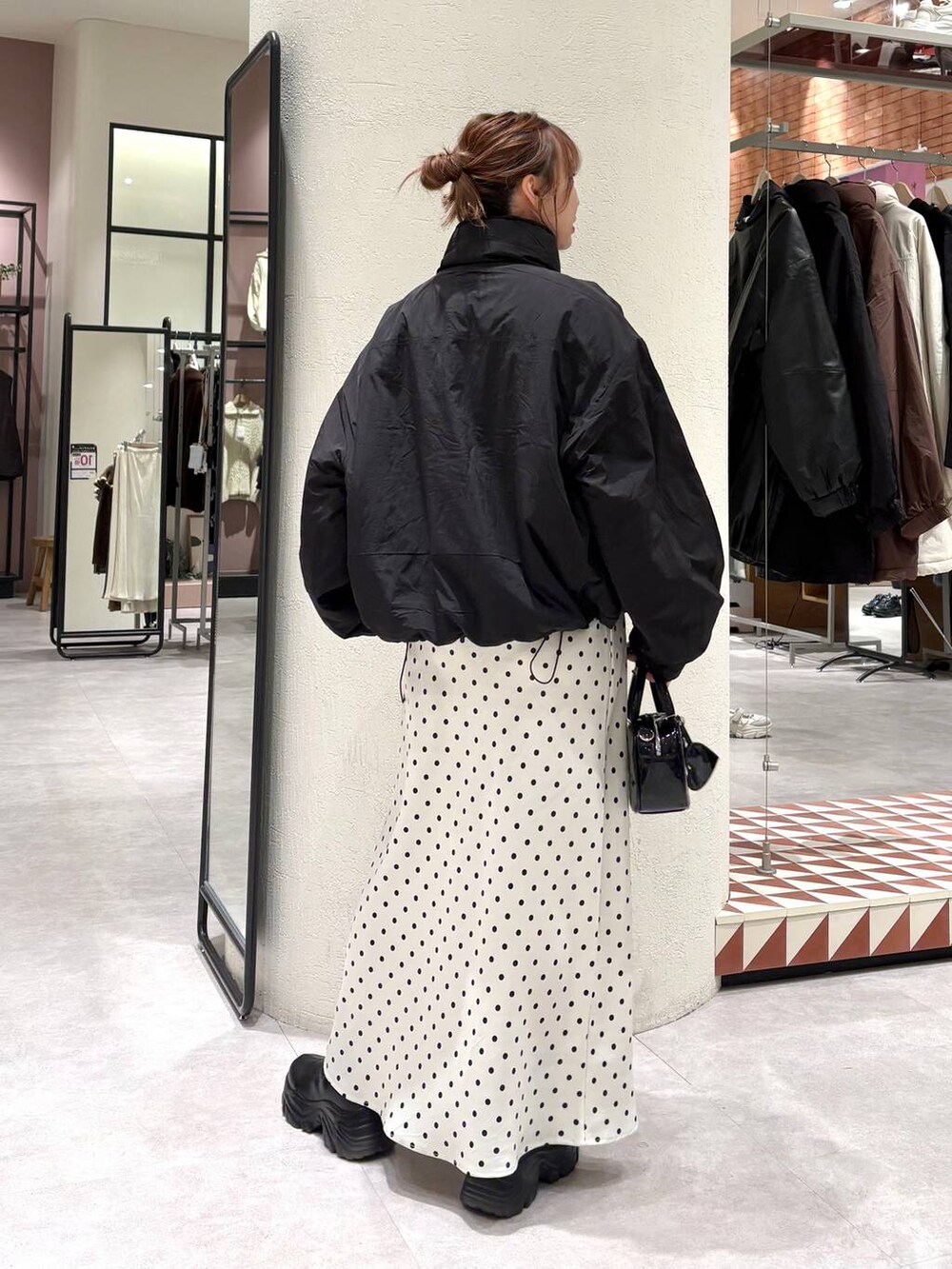 ブラック系のその他アウター、ブラック系のブーツ、ホワイト系のスカートを着用したレディースの秋コーディネートの3枚目の写真