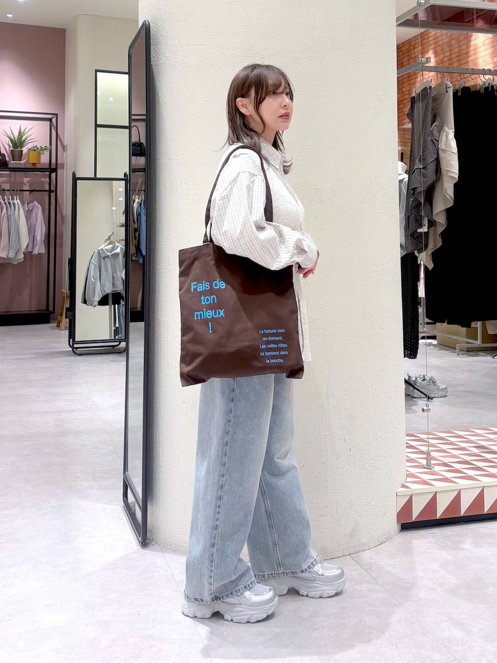 ブルー系のデニムパンツ、ブラウン系のトートバッグ、グレー系のシャツ/ブラウスを着用したレディースの春コーディネートの4枚目の写真