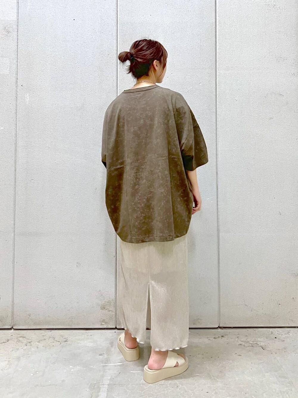 ホワイト系のスカート、ホワイト系のサンダル、ブラウン系のTシャツ/カットソーを着用したレディースの夏コーディネートの2枚目の写真