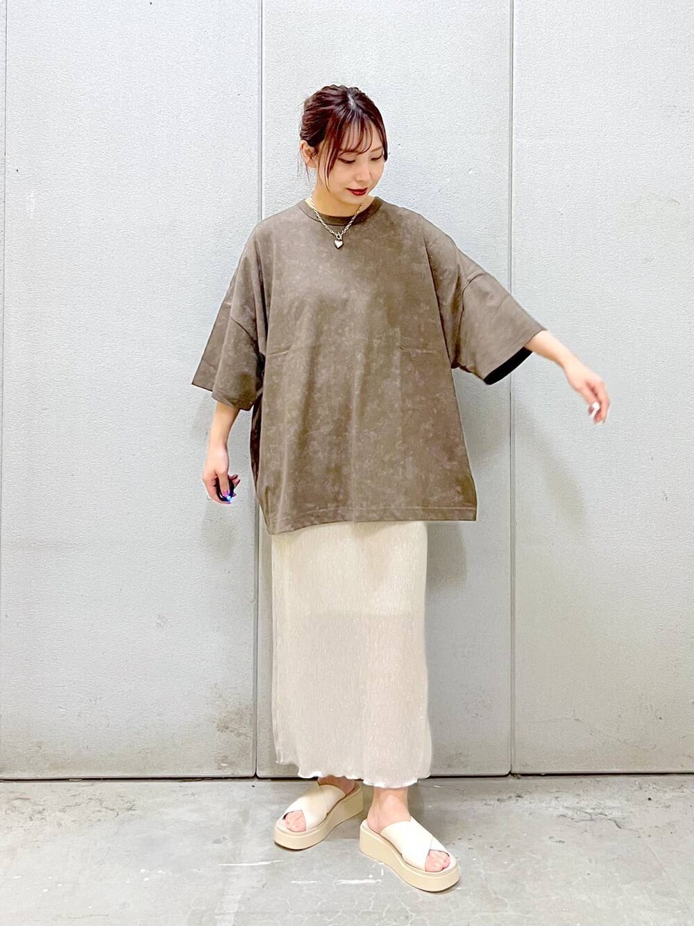 ホワイト系のスカート、ホワイト系のサンダル、ブラウン系のTシャツ/カットソーを着用したレディースの夏コーディネートの4枚目の写真
