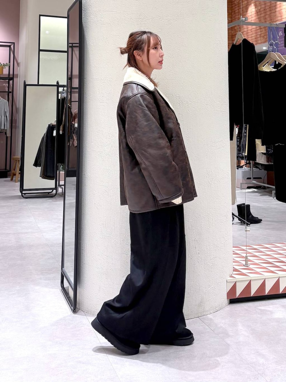 ブラウン系のムートンコート、ブラック系のその他パンツ、ブラック系のブーツを着用したレディースの冬コーディネートの5枚目の写真