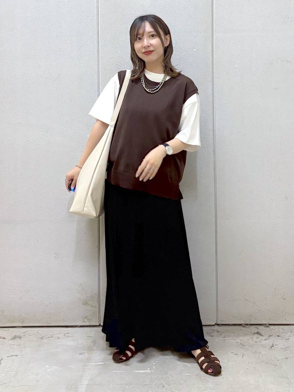 ホワイト系のショルダーバッグ、ホワイト系のTシャツ/カットソー、ブラウン系のサンダルを着用したレディースの夏コーディネートの5枚目の写真