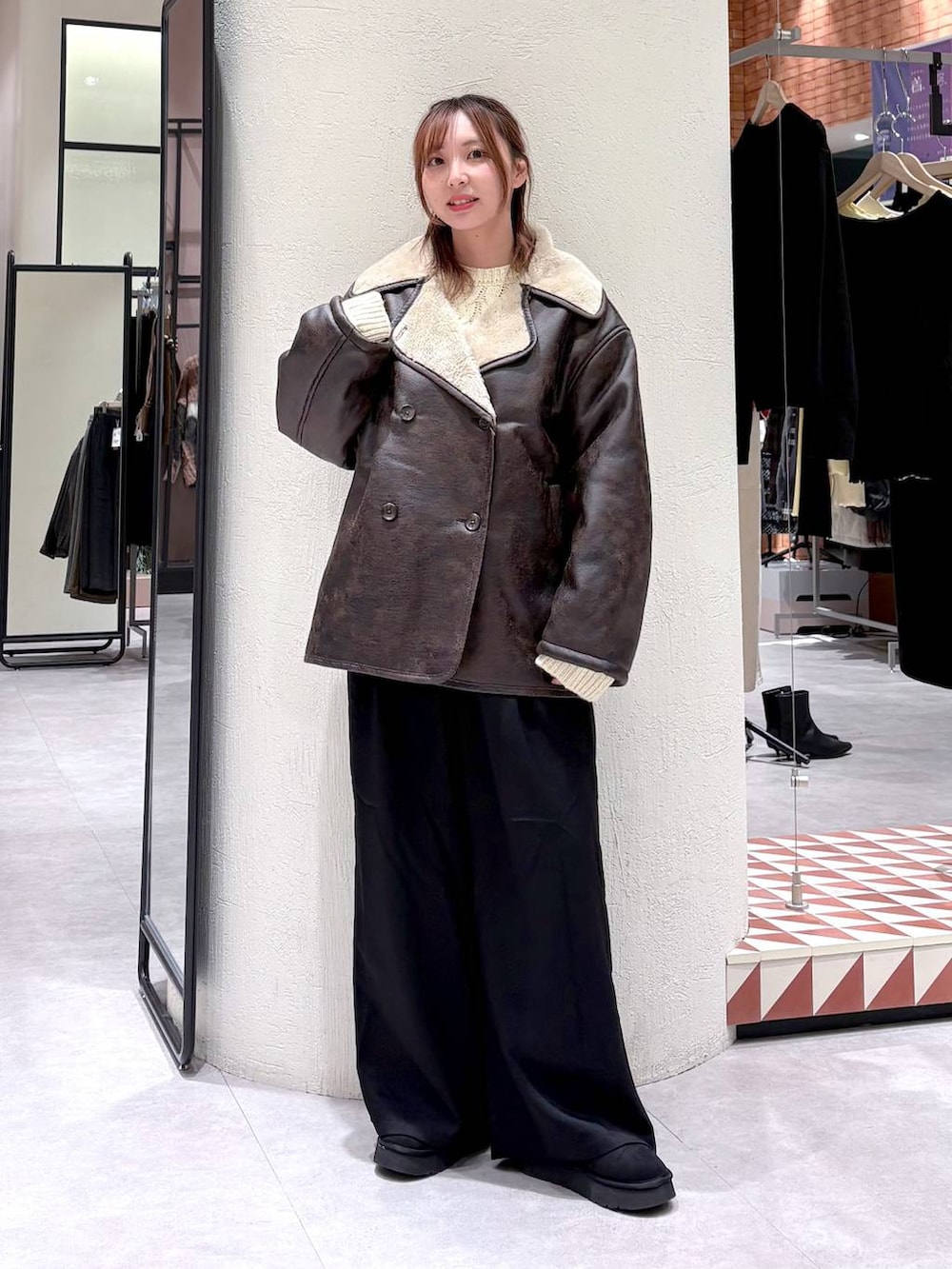 ブラウン系のムートンコート、ブラック系のその他パンツ、ブラック系のブーツを着用したレディースの冬コーディネートの2枚目の写真