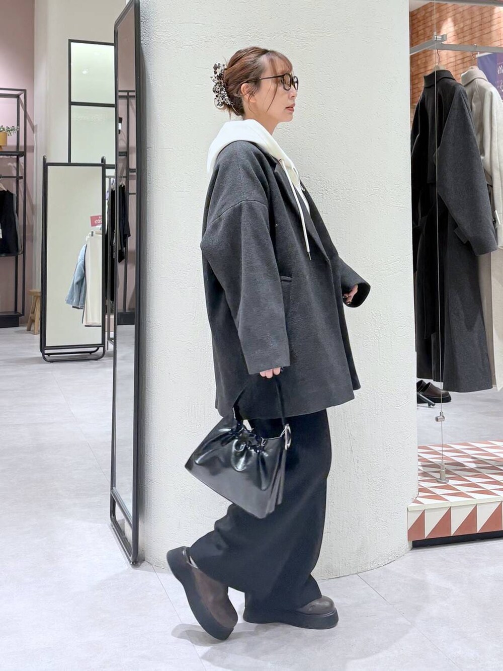 ベージュ系のパーカー、グレー系のその他アウター、ブラック系のスラックスを着用したレディースの冬コーディネートの4枚目の写真