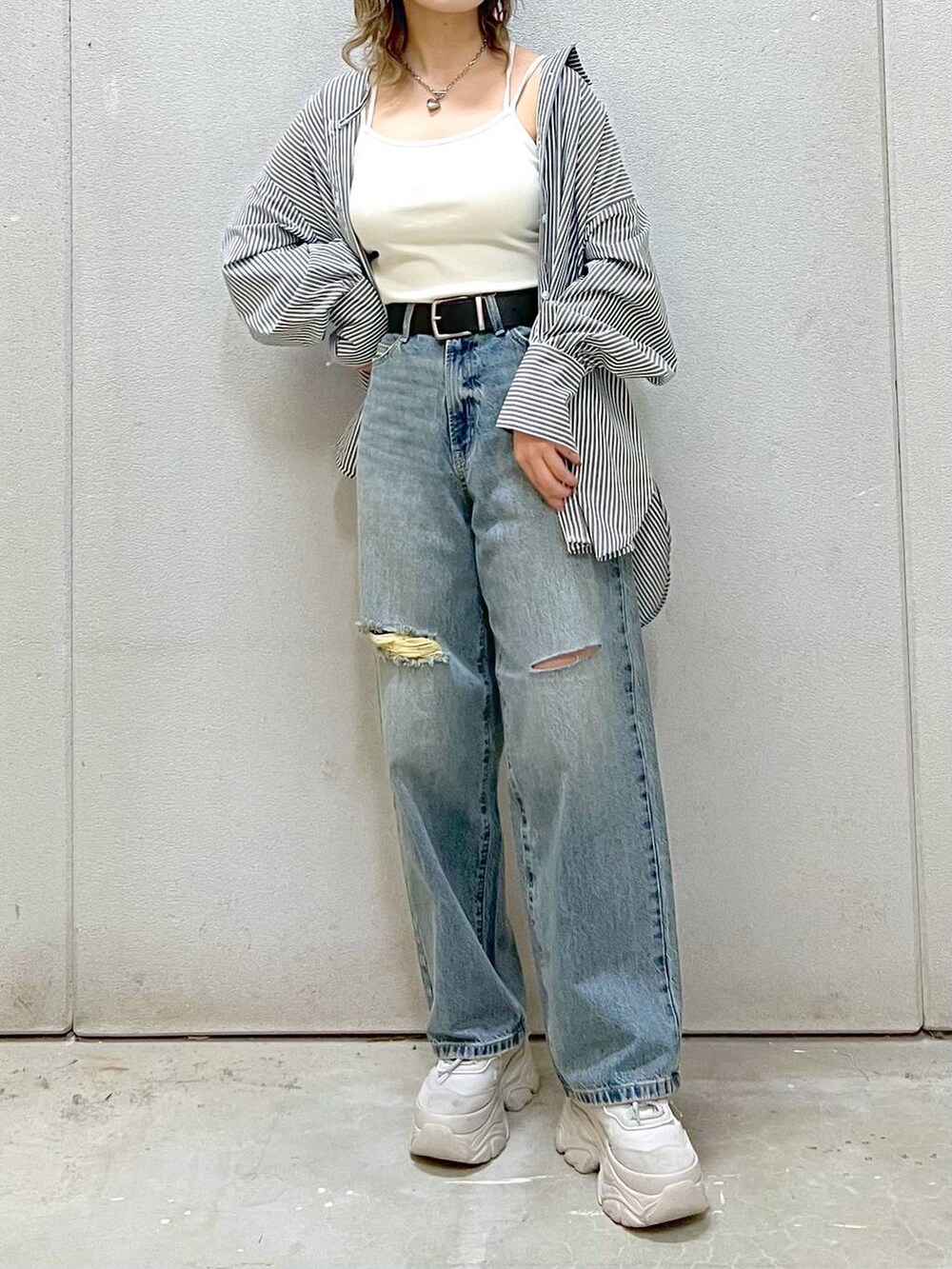 ホワイト系のTシャツ/カットソー、グレー系のスニーカー、ブルー系のデニムパンツを着用したレディースの春コーディネートの2枚目の写真