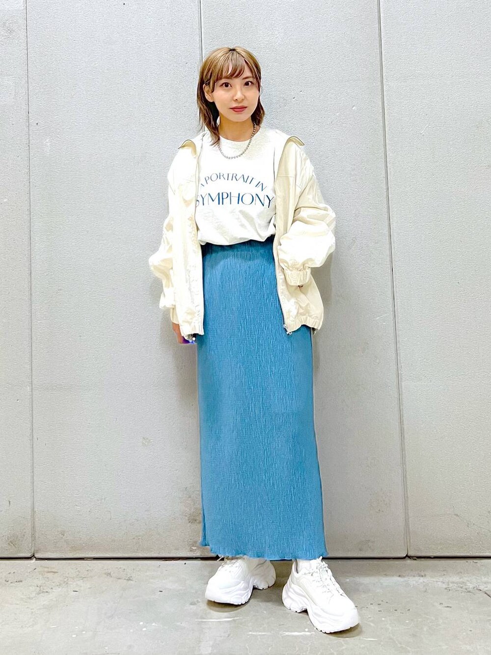 ブルー系のスカート、ホワイト系のスニーカー、グレー系のTシャツ/カットソーを着用したレディースの冬コーディネートの4枚目の写真