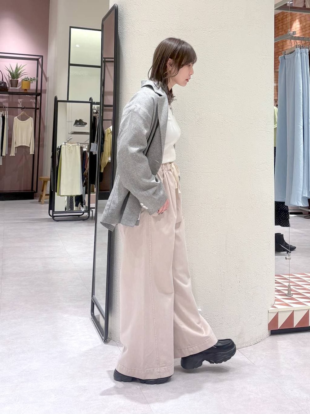 グレー系のテーラードジャケット、ピンク系のデニムパンツ、ブラック系のローファーを着用したレディースの冬コーディネートの5枚目の写真